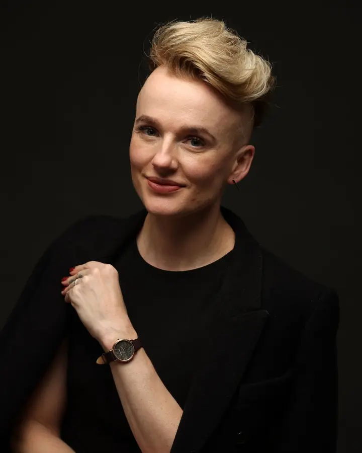 Magdalena Czajor, ProLash Ireland trainer, seated in a black dress and jacket against a dark studio background
