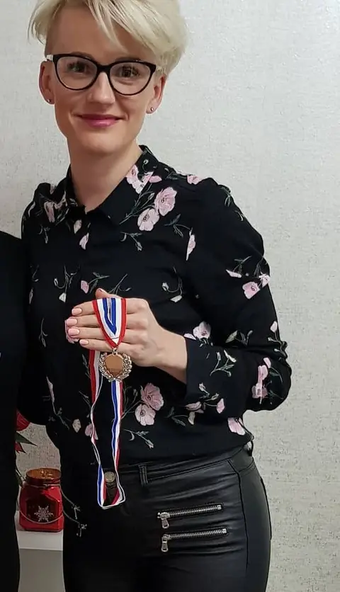 Magdalena Czajor holding a medal on a ribbon